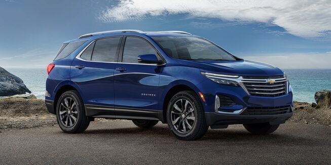 Front side profile view of the 2023 Chevrolet Equinox stopped on a mountain road near the ocean.