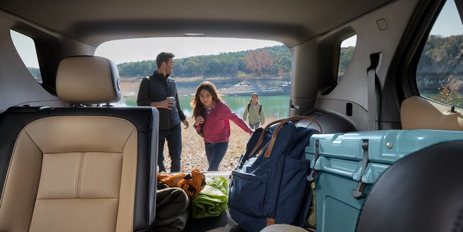 A young family finishes up their camping trip by loading up their 2023 Chevrolet Equinox.