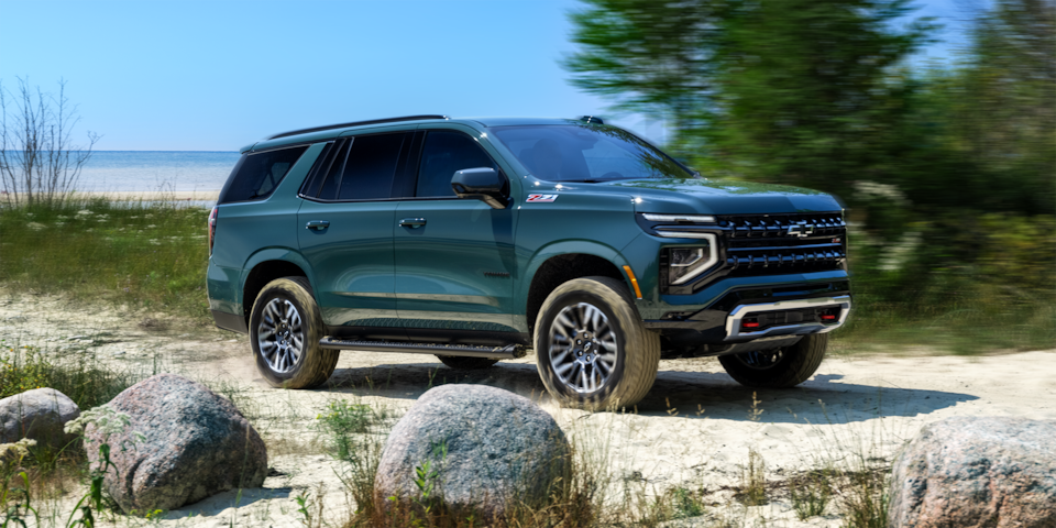 Wide side view of the 2025 Chevrolet Tahoe SUV parked by the beach.
