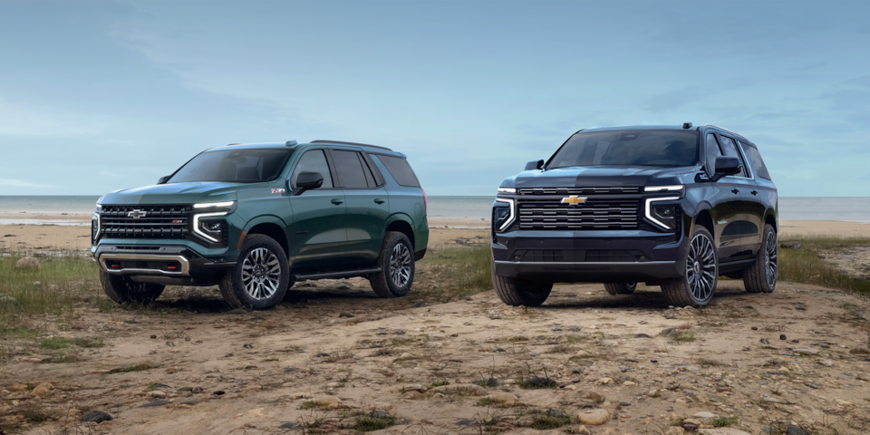 The 2025 Chevrolet Tahoe and 2025 Chevrolet Suburban parked on sand.