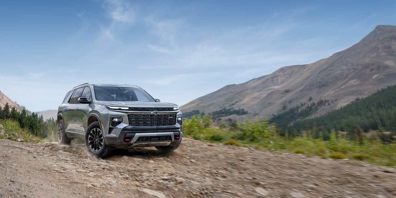 Vue latérale avant du VUS Chevrolet Traverse 2025 en mouvement seul à l’extérieur par une journée ensoleillée.