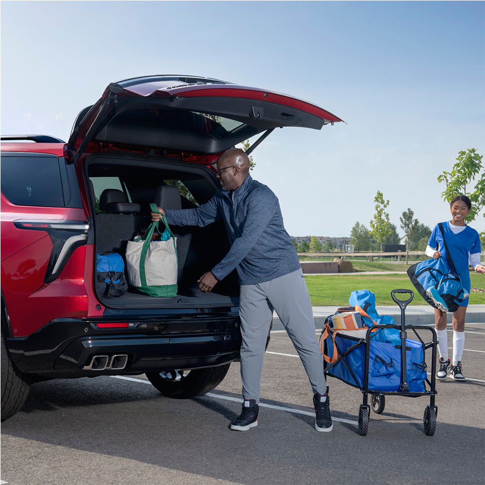 Une personne range des sacs dans le coffre du VUS Chevrolet Traverse 2025.