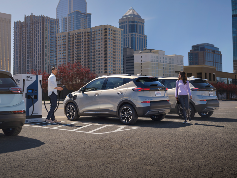 Une personne recharge son VÉ Chevrolet à une station de recharge électrique publique.
