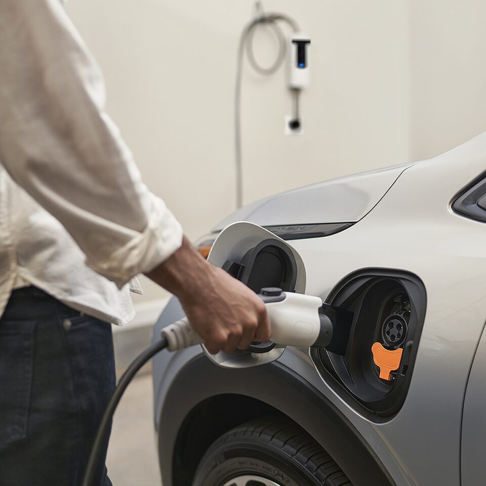 Une personne recharge son VÉ Chevrolet à une station de recharge.