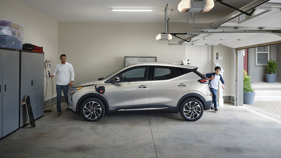 Une personne recharge son VÉ Chevrolet dans son garage.
