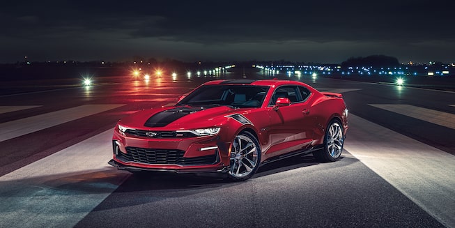 Vue latérale avant gauche de la Camaro 2023 la nuit.