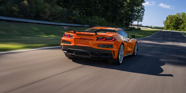 Rear profile view of the 2023 Chevrolet Corvette driving on a road.