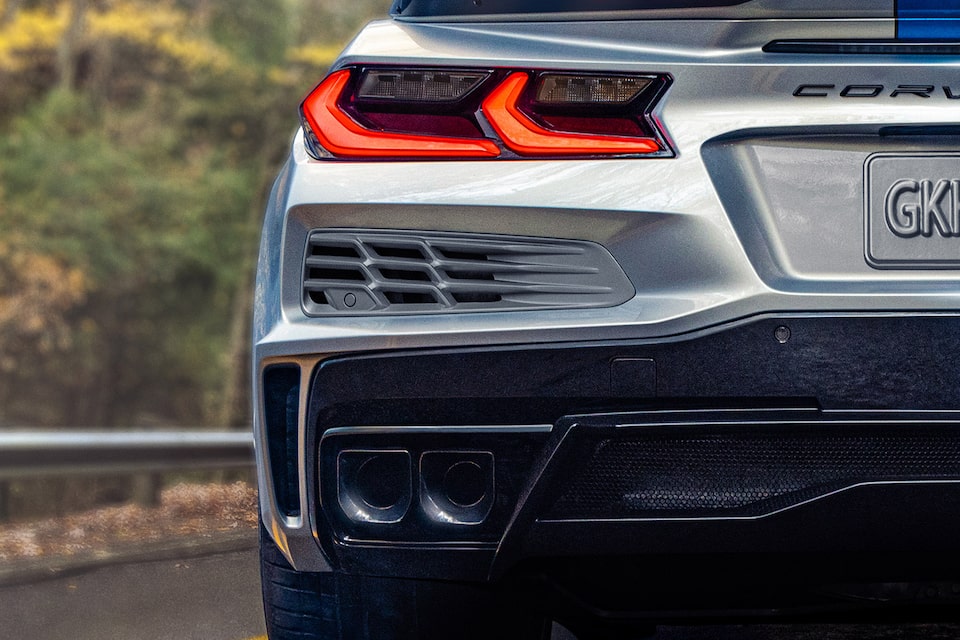 Vue arrière de la Chevrolet Corvette 2024 à côté d’ une forêt.