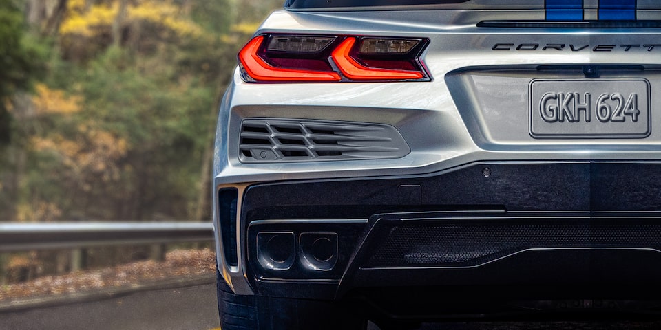 Vue arrière de la Chevrolet Corvette 2024 à côté d’une forêt.