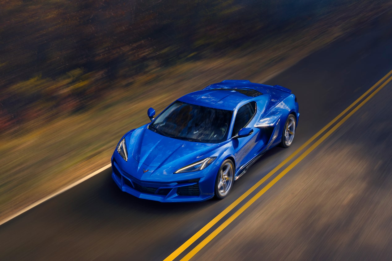 The 2024 Chevrolet Corvette E-Ray driving on a road from an aerial view.
