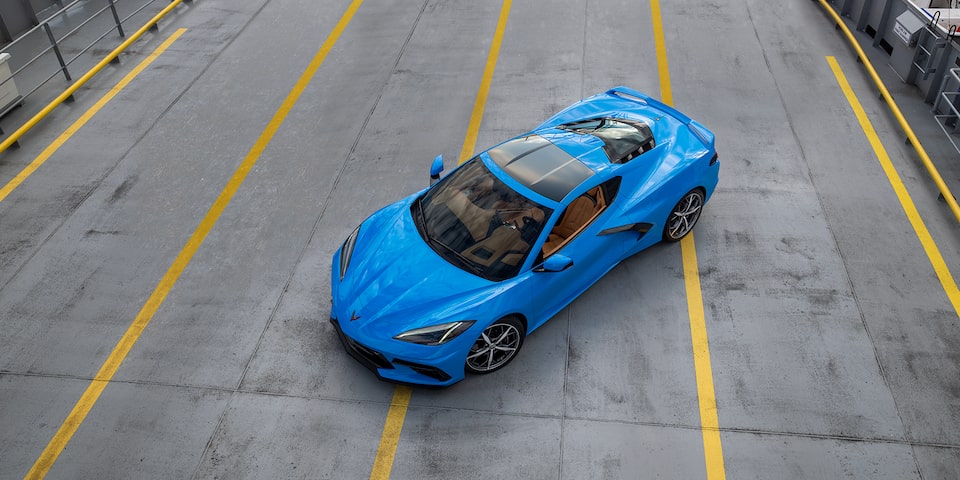 Vue aérienne de la Corvette Stingray 2024 en bleu rapide stationnée au milieu d’une route.