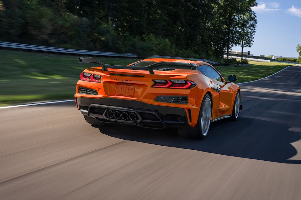 A 2024 Corvette Z06 cruises away on a roadway on a sunny day.