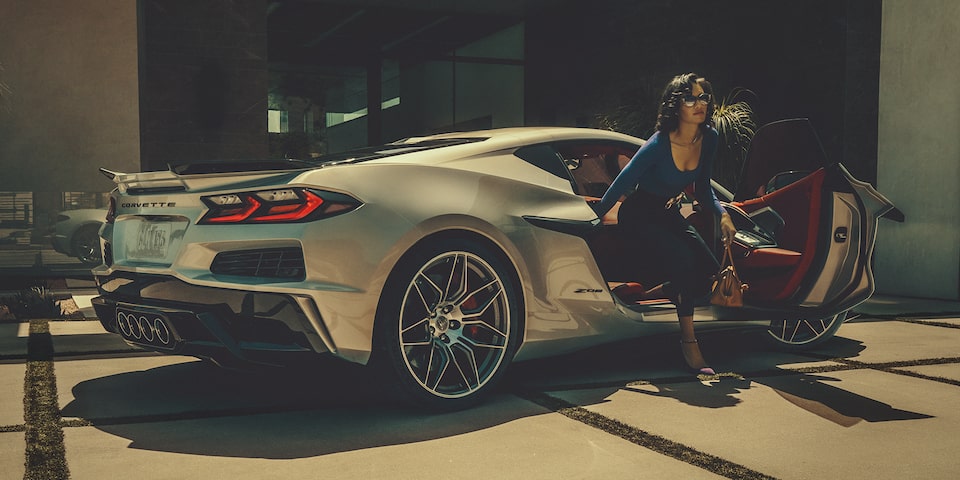 A lady exits the passenger side of the Corvette Z06.