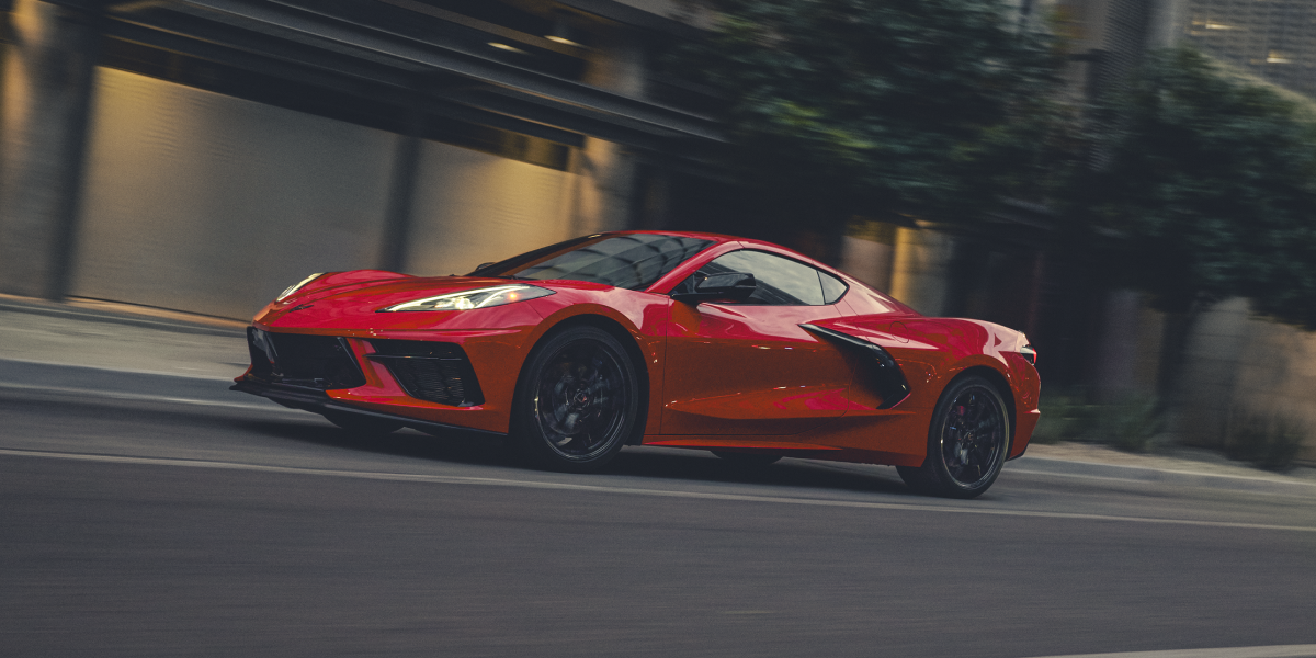 Side view of the 2025 Chevrolet Corvette Stingray driving fast in the city.