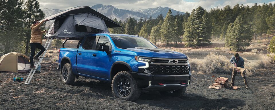 Person setting up the truck bed tent on the 2022 Chevrolet Silverado 1500.