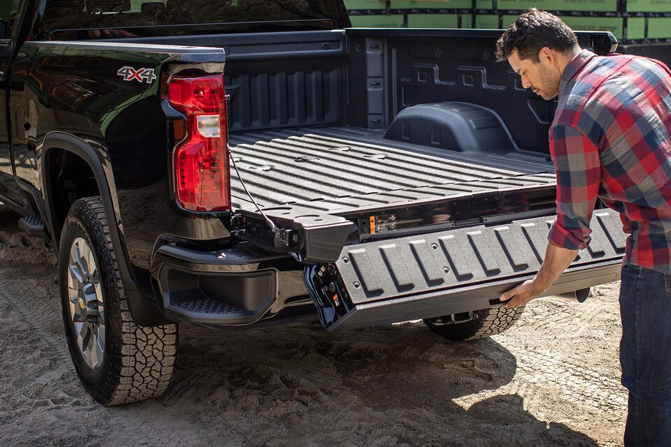 Un homme ajuste le hayon Multi-Flex du Chevrolet Silverado HD 2023.