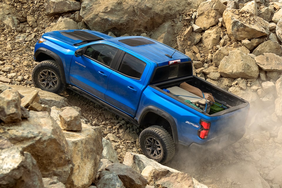 The 2024 Chevrolet Colorado driving through a rocky trail.