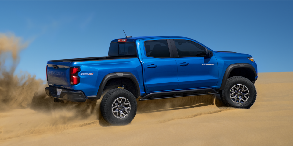 The 2024 Chevrolet Colorado driving off-road through sand.