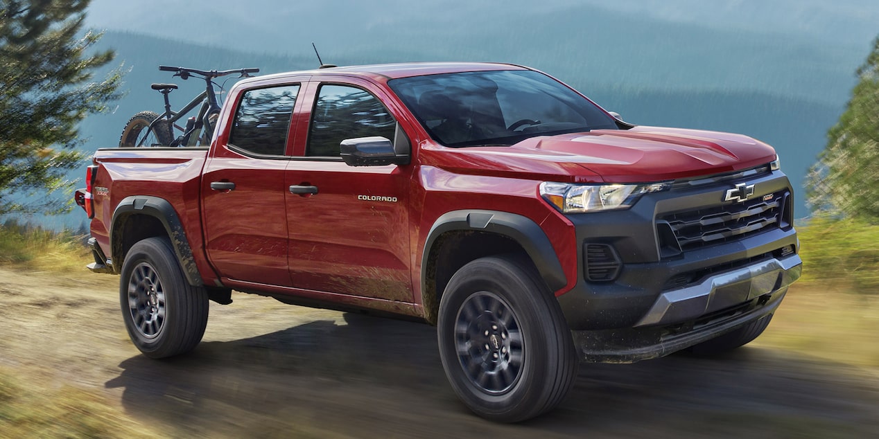 Vue latérale d’un Chevrolet Colorado 2025 rouge stationné en haute altitude.