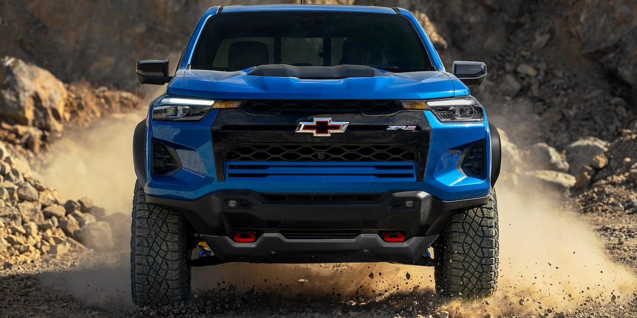 Vue avant d’un Chevrolet Colorado 2025 bleu dérapant sur un terrain rocheux.