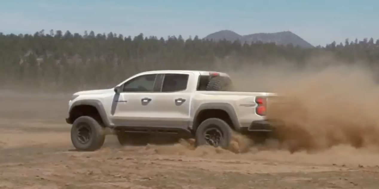 Side view of a white 2025 Chevrolet Colorado ZR2 skidding on a desert.