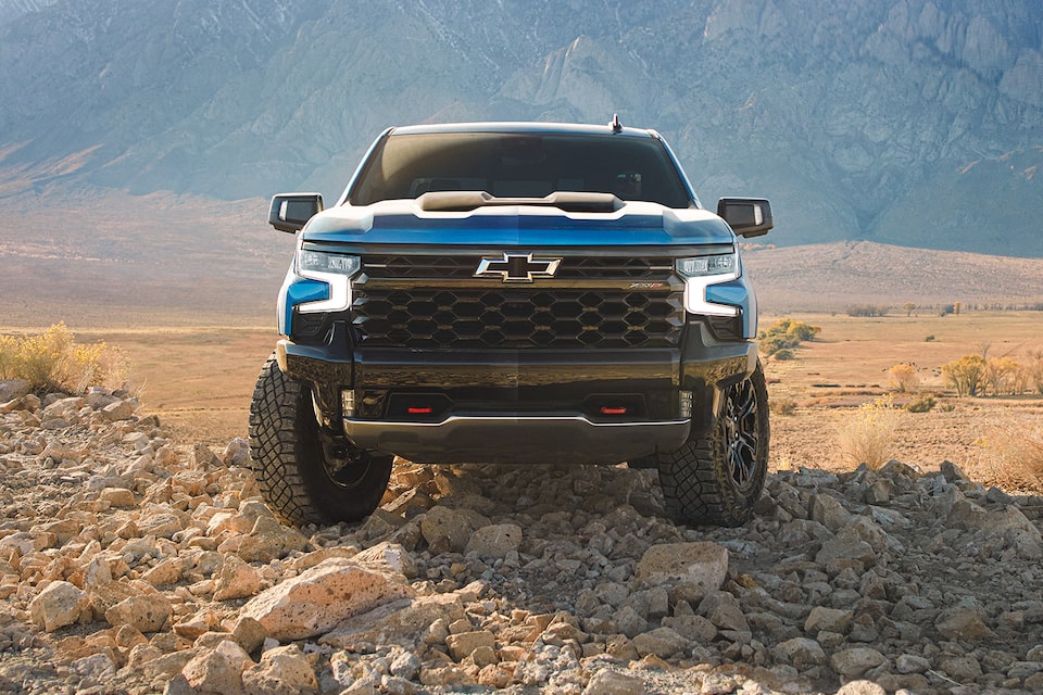 Front view of the 2024 Chevrolet Silverado on a sandy terrain.