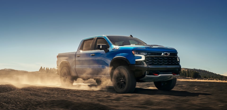 The 2024 Chevrolet Silverado driving on a sandy terrain.