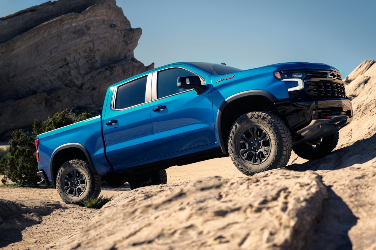 Blue Chevrolet Silverado ZR2 off-road truck Driving Uphill on a Rocky Terrain.