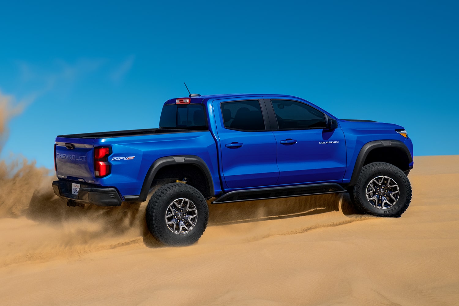 Side view of a Chevrolet Colorado ZR2 off-road truck driving alone in the desert.