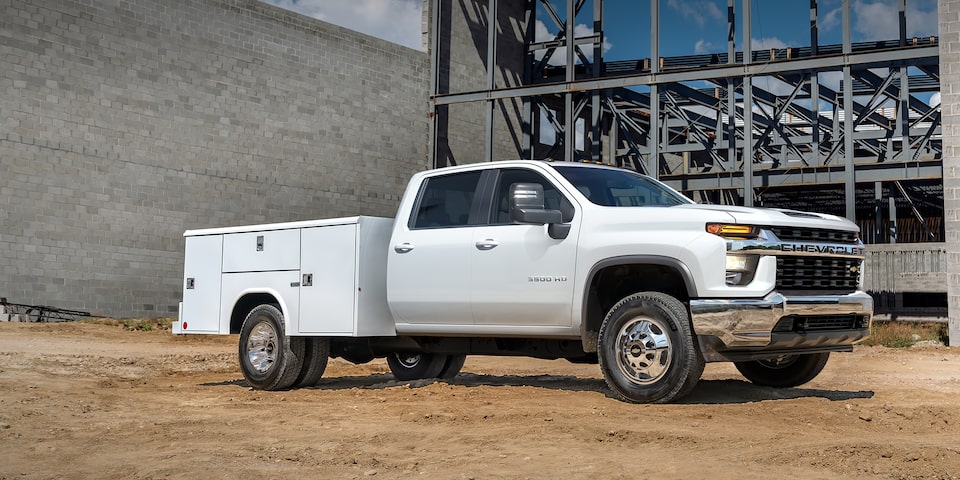 Châssis-cabine Chevrolet Silverado 3500 HD 2023 avec remorque utilitaire sur un chantier de construction.