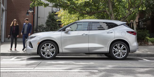 Parked 2020 Blazer Side View With 2 People Walking Towards The Vehicle.