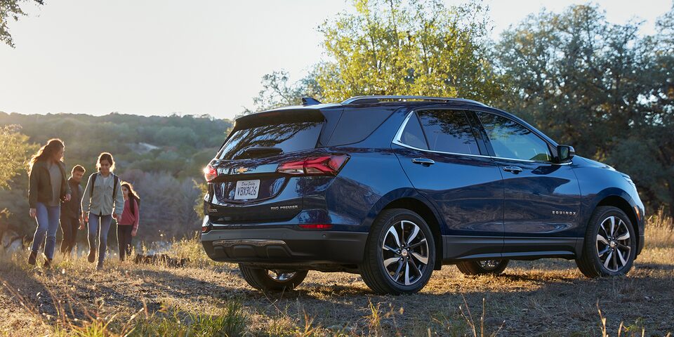 Family Walking Towards Parked 2022 Chevy Equinox Small SUV: Rear Three-Quarter View