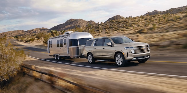 2022 Chevrolet Suburban Large 3-Row SUV Exterior Front Side View Pulling Trailor.