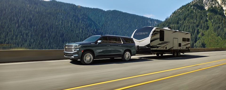 2022 Chevrolet Suburban Large 3-Row SUV Exterior Front Side View Pulling Trailer.