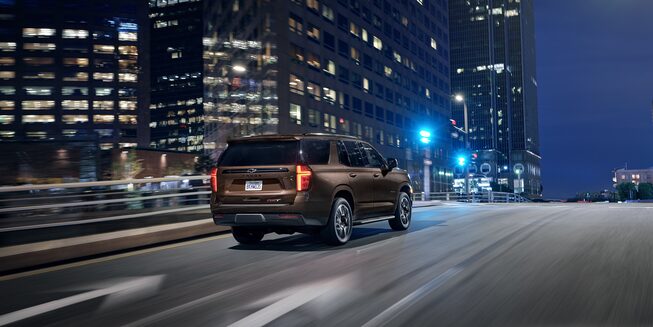 Chevrolet Tahoe Full-Size SUV Exterior Rear Side View Driving.