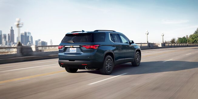 2022 Chevrolet Traverse Mid-Size SUV Exterior Rear Side View Driving on Highway.