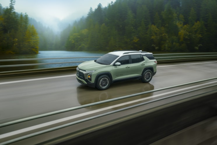 Side view of a Chevrolet Equinox compact SUV driving fast on a bridge.