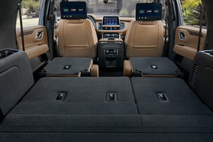 Rear view of the interiors of a Chevrolet SUV with its second and third row seats folded down.