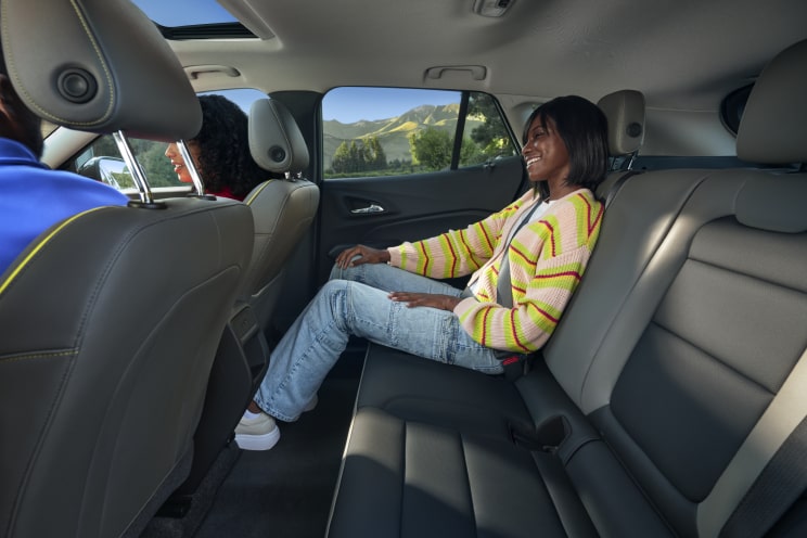 A person seated comfortably on the second row of a Chevrolet SUV.