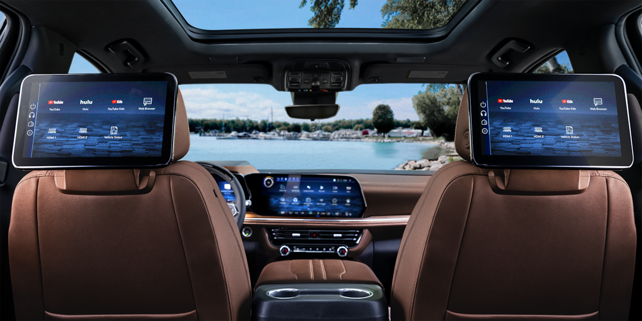 Rear passenger's view of the interiors of the 2025 Chevrolet Suburban with the infotainment screens turned on.