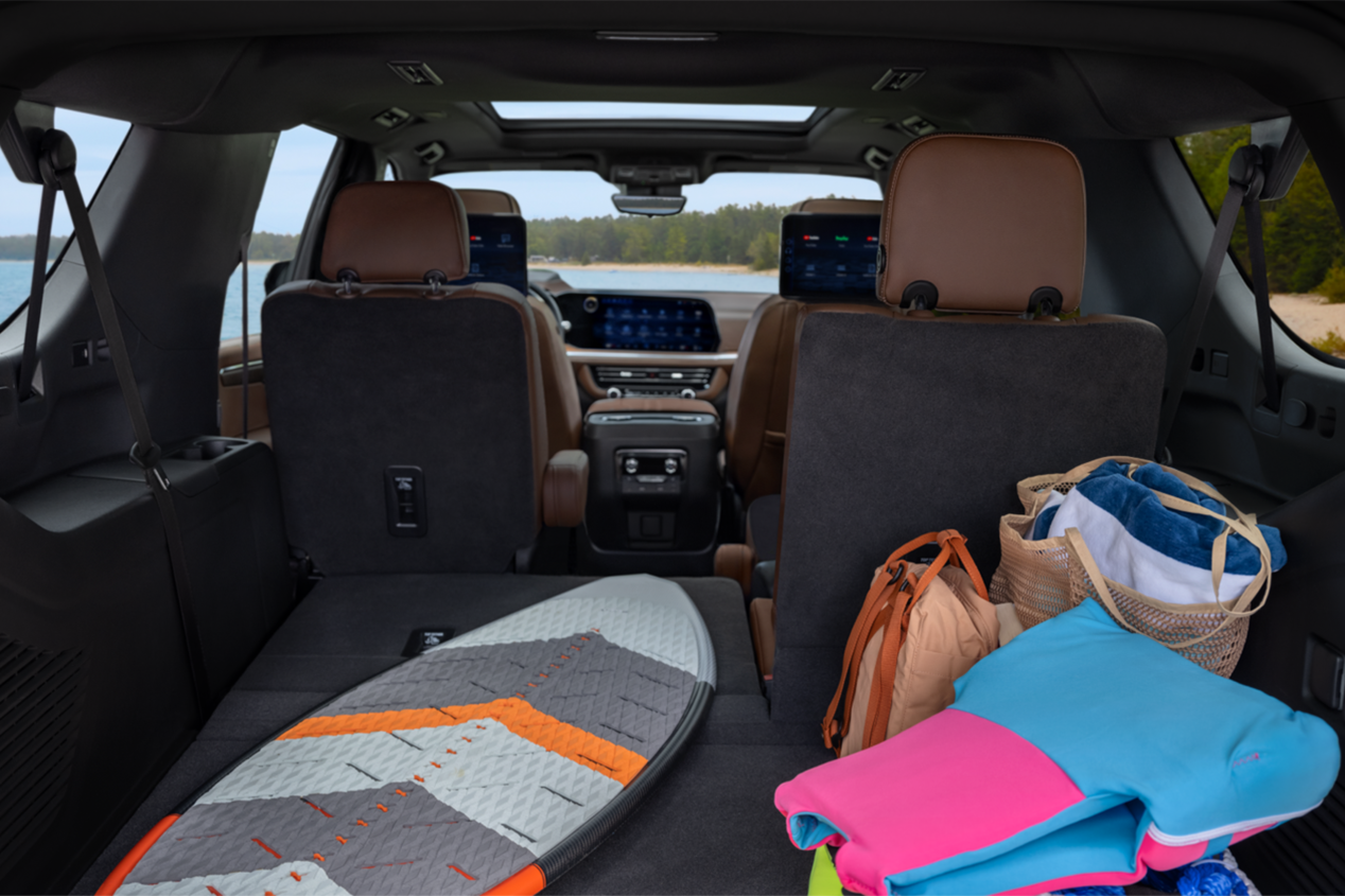 Back view of the trunk with rear seats folded down and surfing items stowed in the 2025 Chevrolet Suburban SUV.