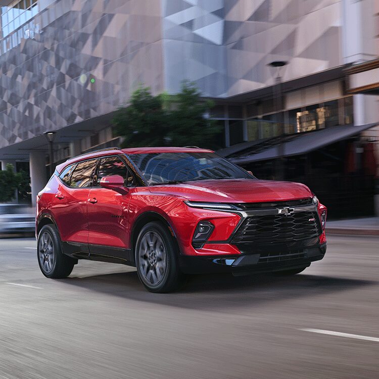 Un Chevrolet Blazer 2026 rouge en mouvement au centre-ville.