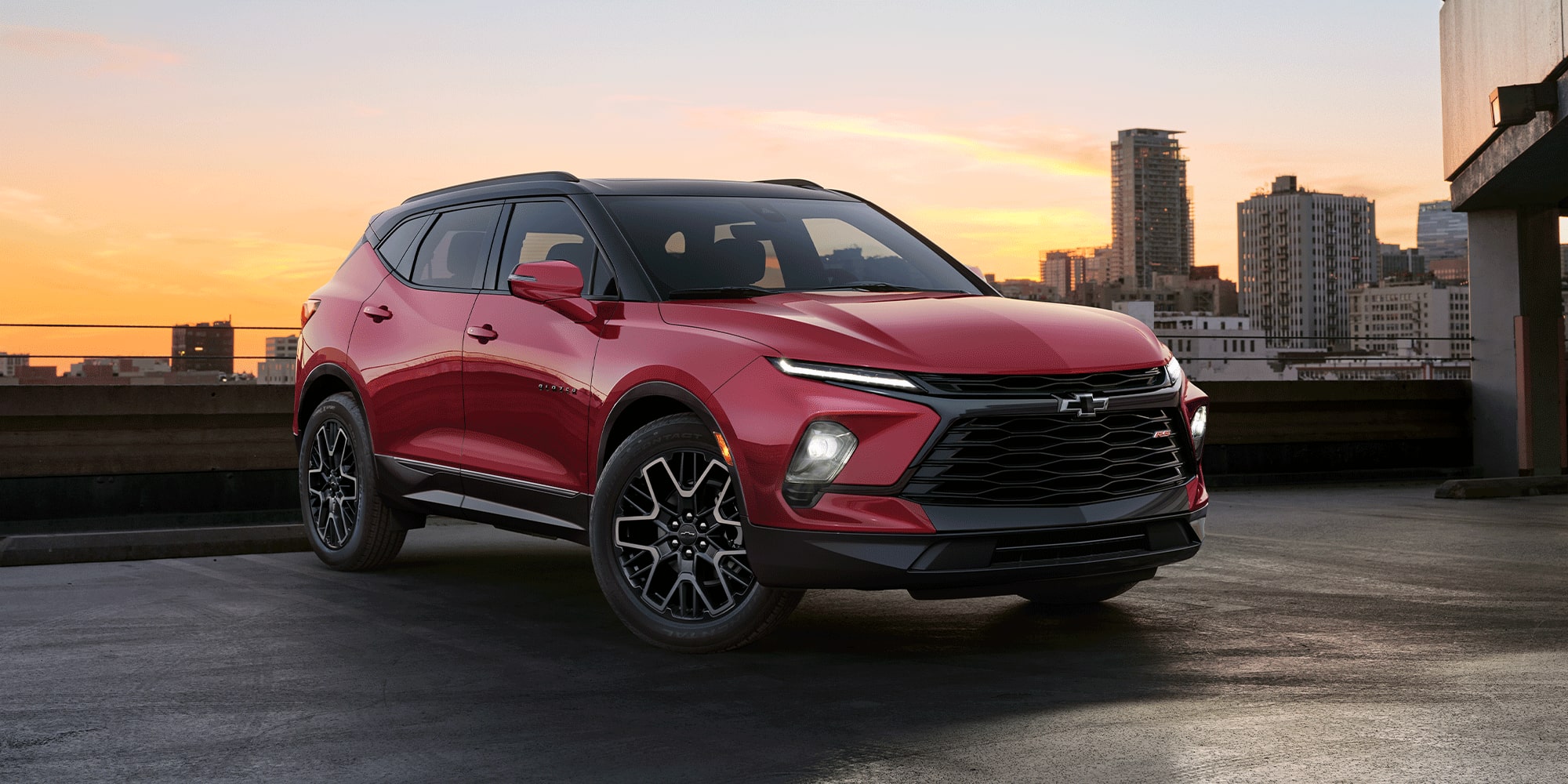 Le Chevrolet Blazer 2026 en teinte rouge éclatant stationné sur le toit d’un bâtiment.