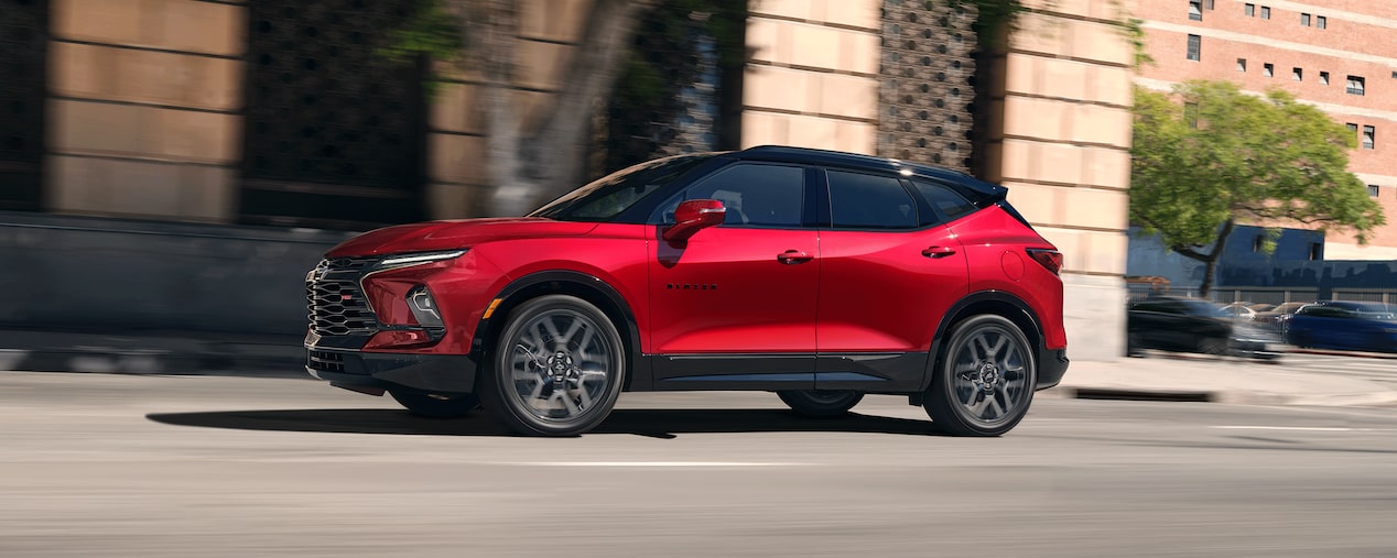 A 2026 Chevrolet Blazer in Radiant Red Tintcoat colour driving in the city.