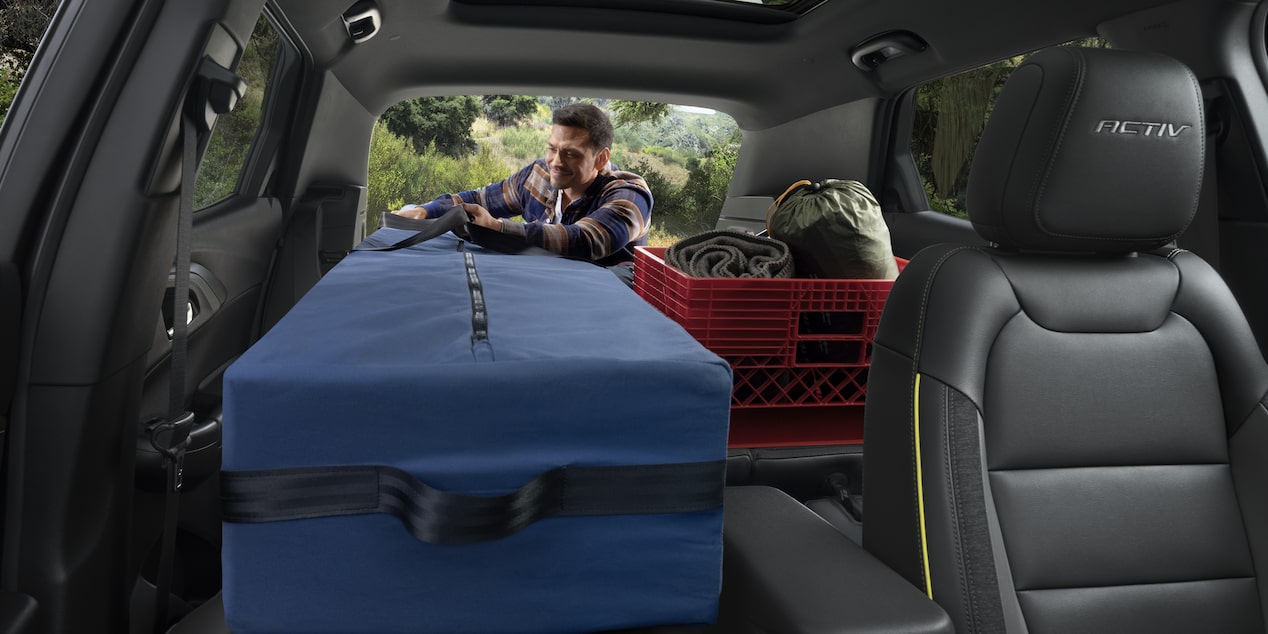A person folding the front passenger seat of the 2026 Chevrolet Trailblazer ACTIV trim.