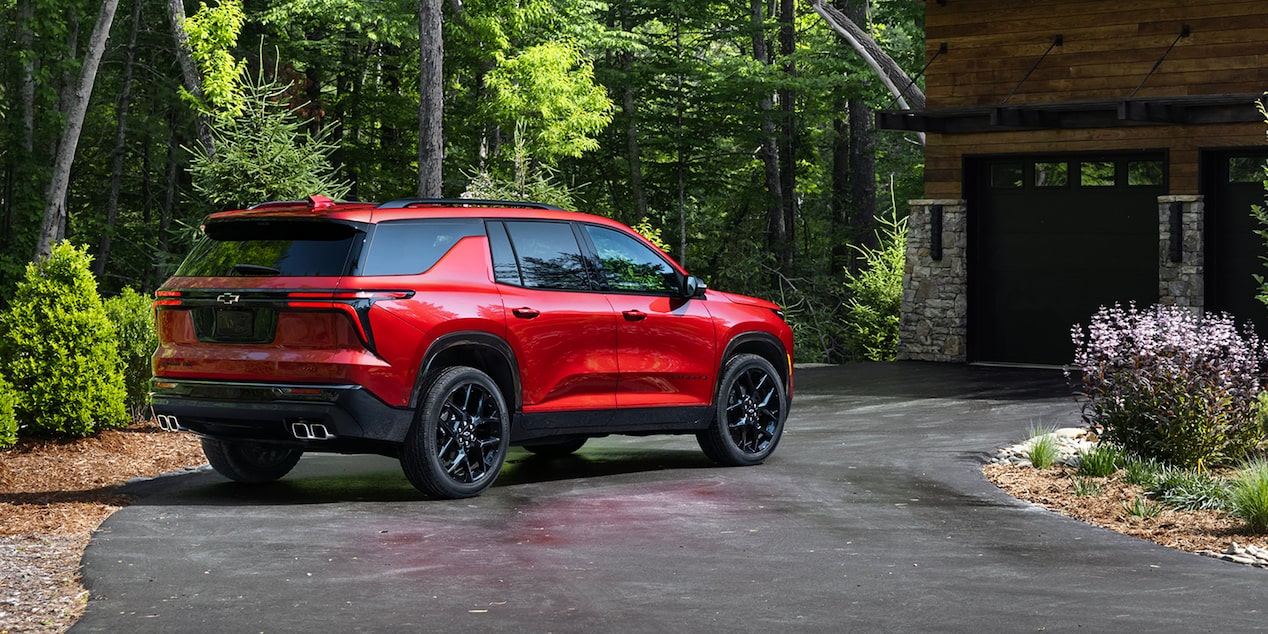 2026 Chevrolet Traverse Parked in the Driveway of a Cabin in the Woods.