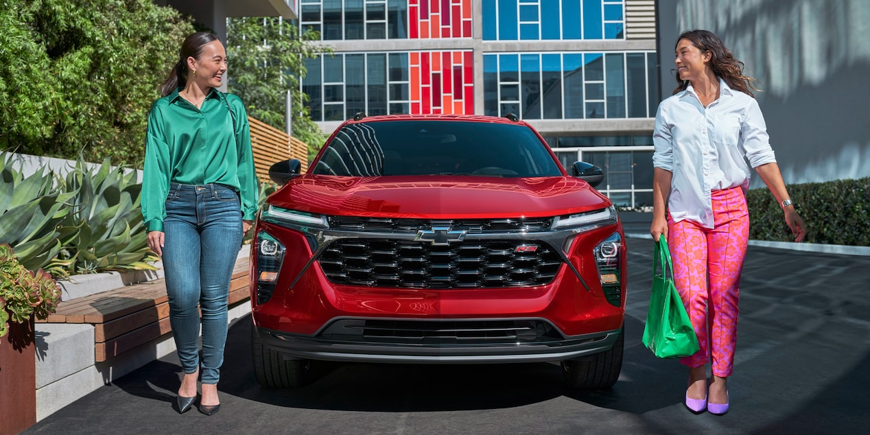 Two People Walking Away from their 2026 Chevrolet Trax Parked at a Mall.