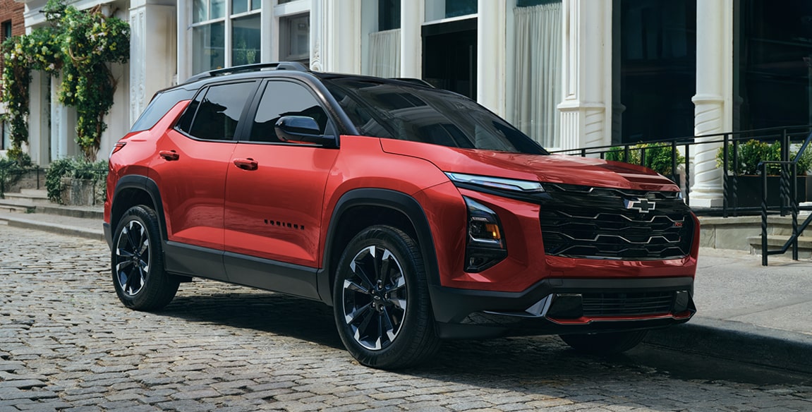 Side view of the 2027 Chevrolet Equinox parked outside a building.