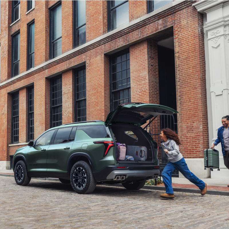Une personne rangeant des sacs dans le coffre d’une Chevrolet Traverse 2027.