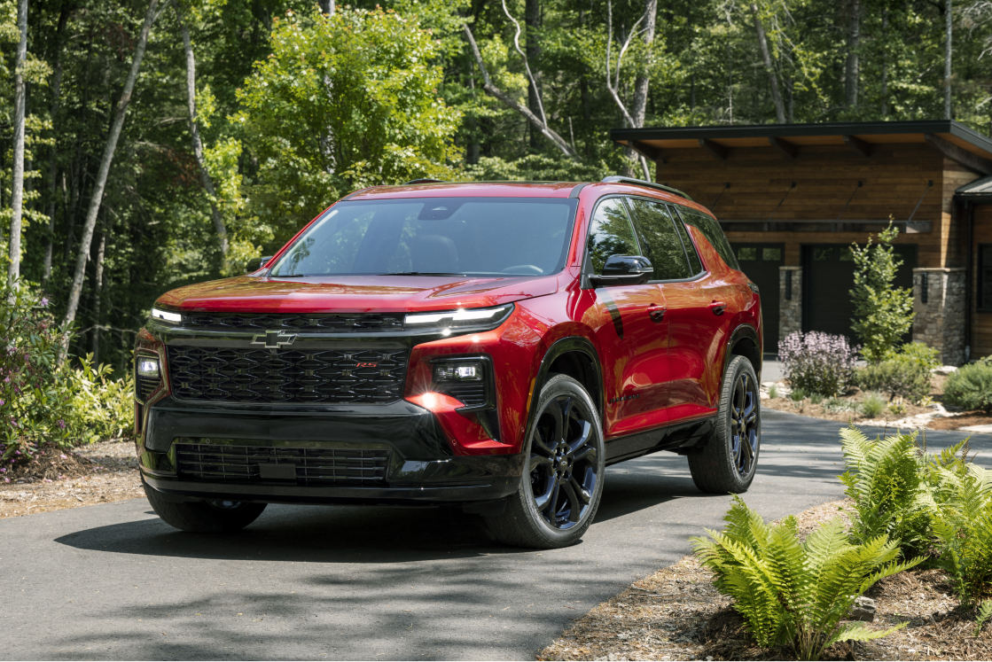 Vue de face de la Chevrolet Traverse 2027 stationnée sur un trottoir bordé d’arbres.
